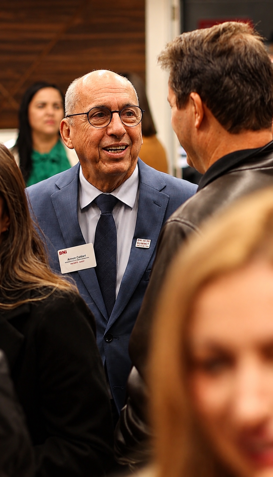 Dr. Arnoni Caldart sorrindo em meio a participantes de um evento